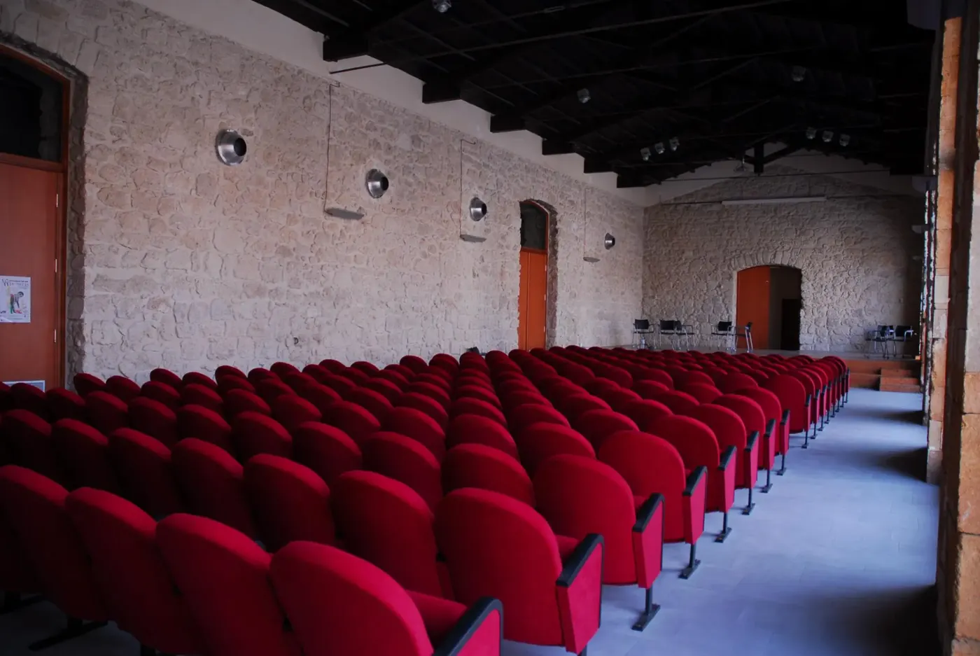 Auditorium with red seats and stone arches